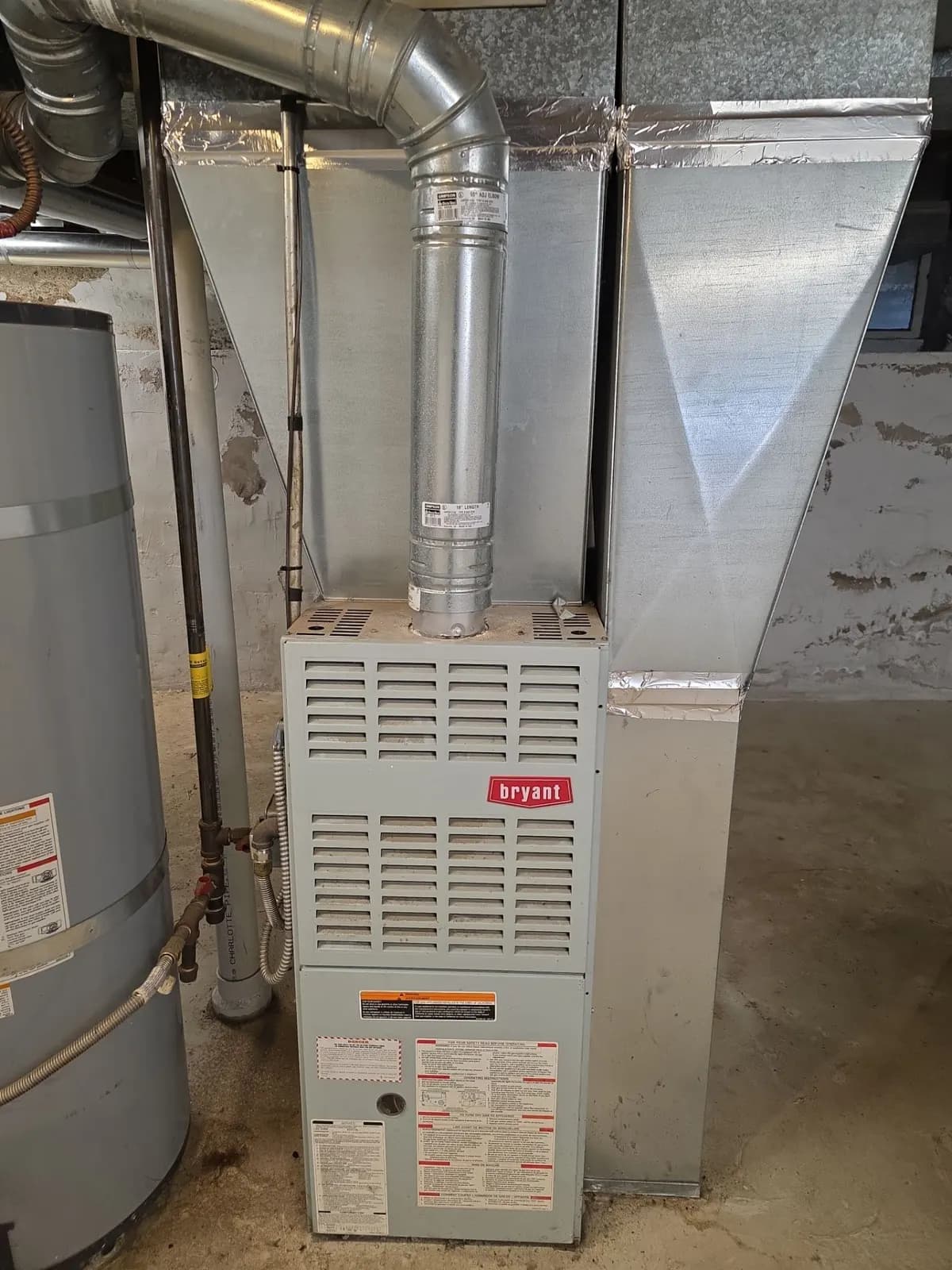 Upflow gas furnace in a basement with galvanized vent pipe and sheet metal plenum