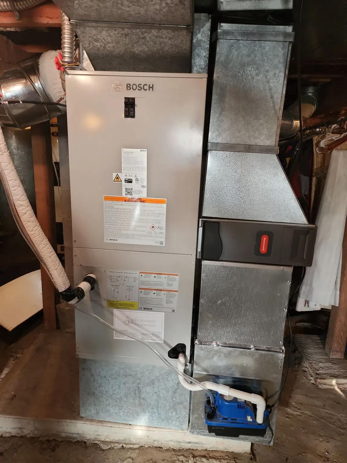Vertical Bosch air handler in a basement with a sheet metal plenum, media filter cabinet and condensate pump