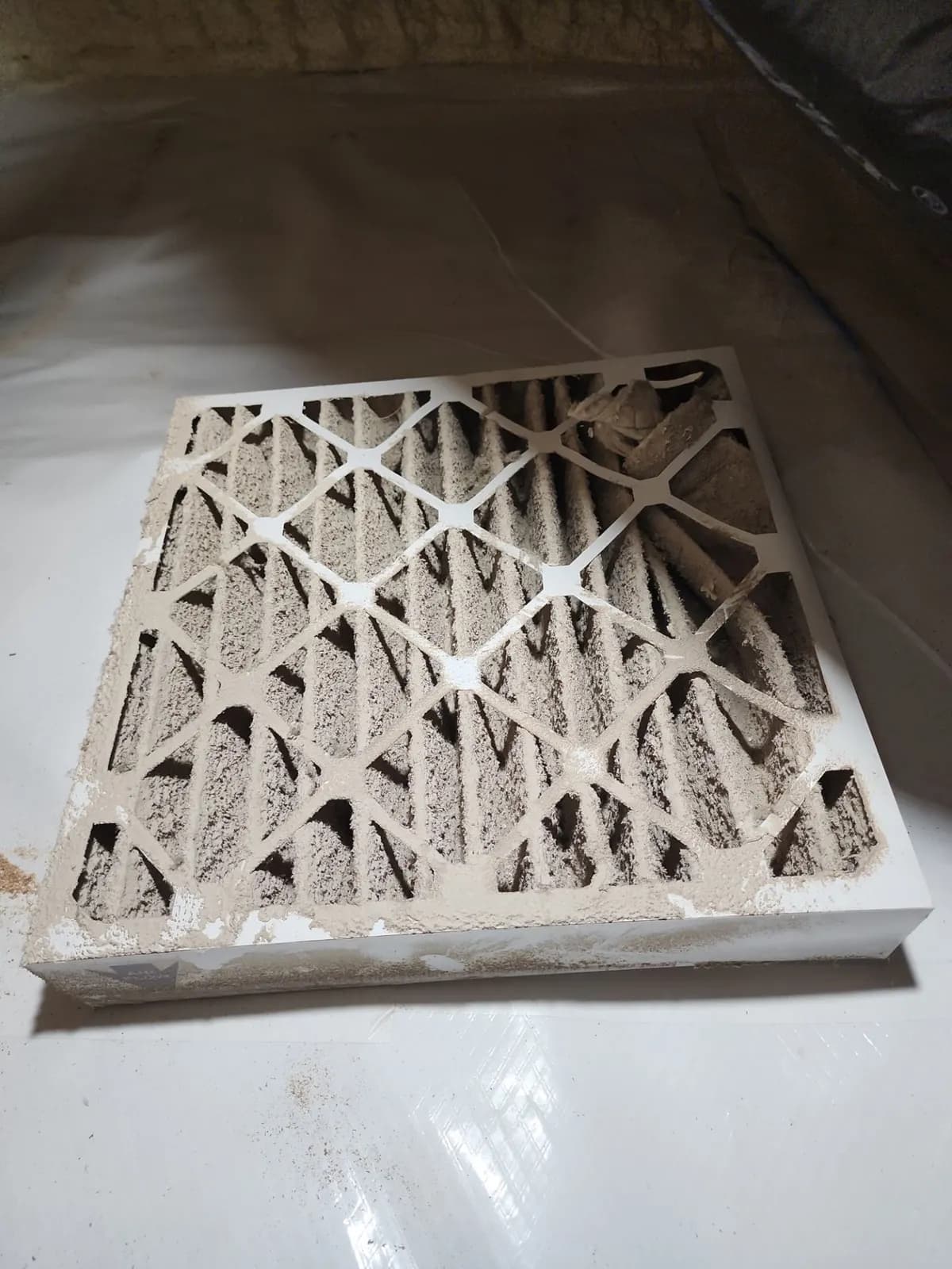 Pleated air filter completely caked with gray dust
