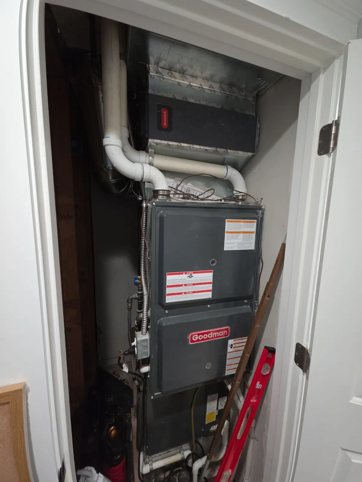 High-efficiency gas furnace in a hallway closet with PVC venting and an air filter cabinet
