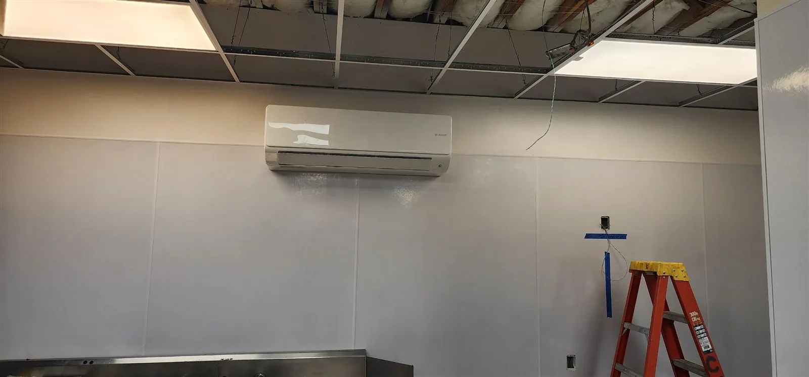 Wall-mounted ductless mini split head in a commercial room