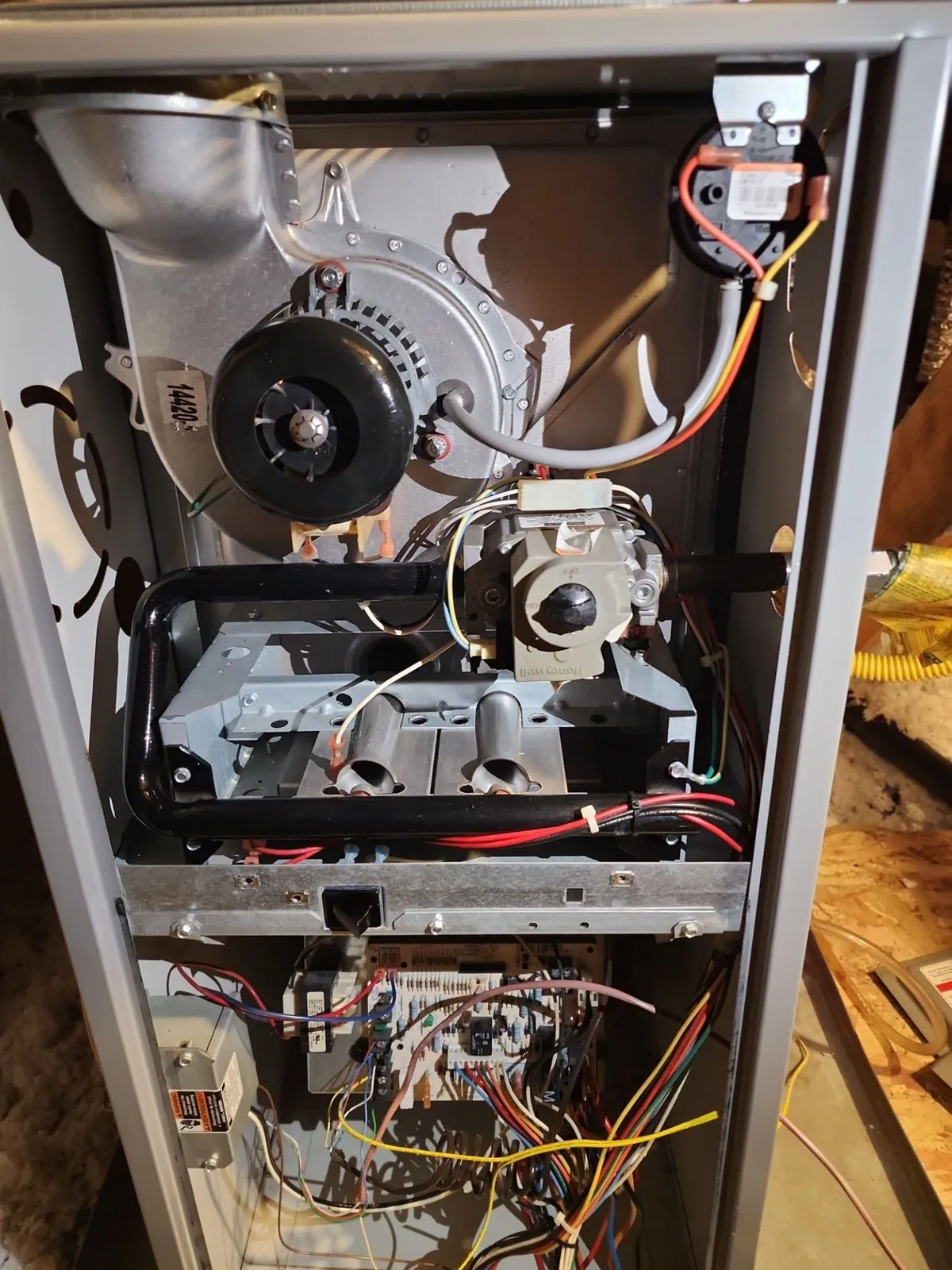Gas furnace with front panel removed showing inducer motor, gas valve and burners
