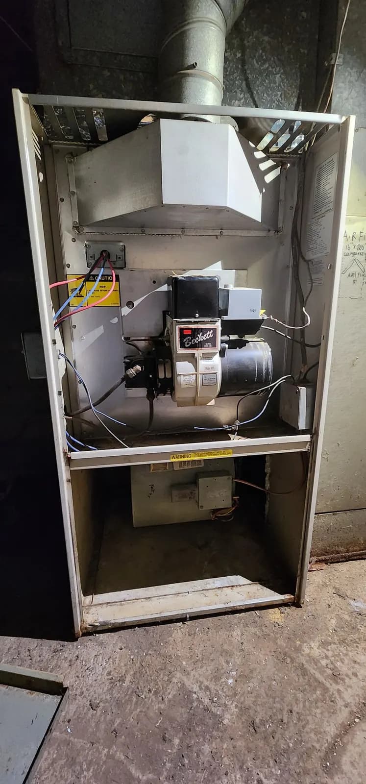 Oil furnace with the front panels removed showing the oil burner and blower compartment