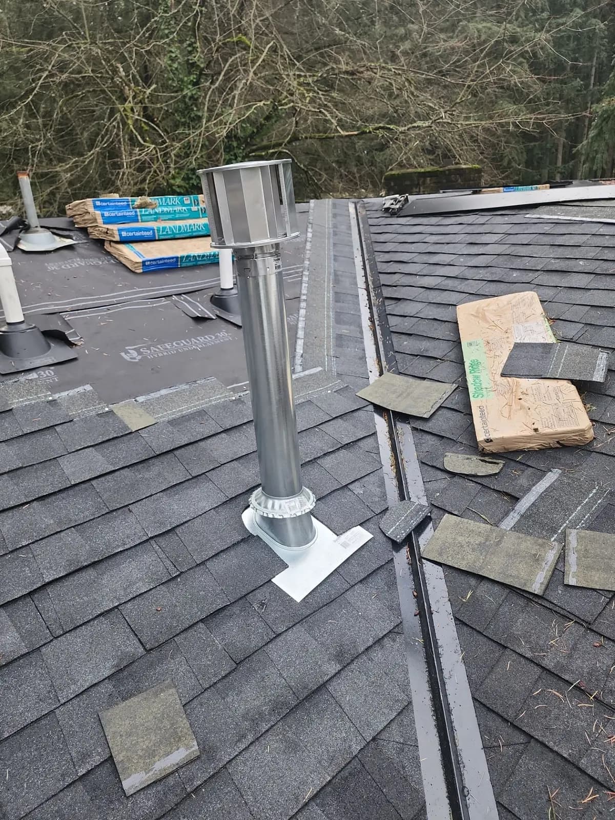 Galvanized vent pipe with a cap and flashing through a shingle roof