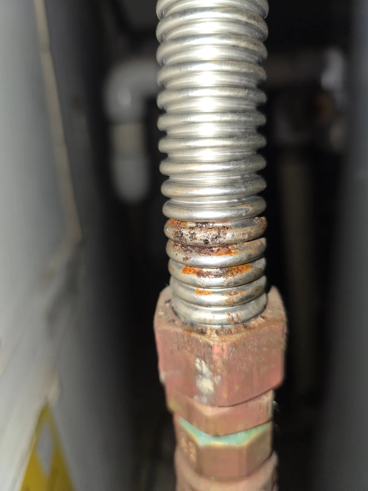 Flexible stainless gas connector with heavy rust and pitting at the fitting