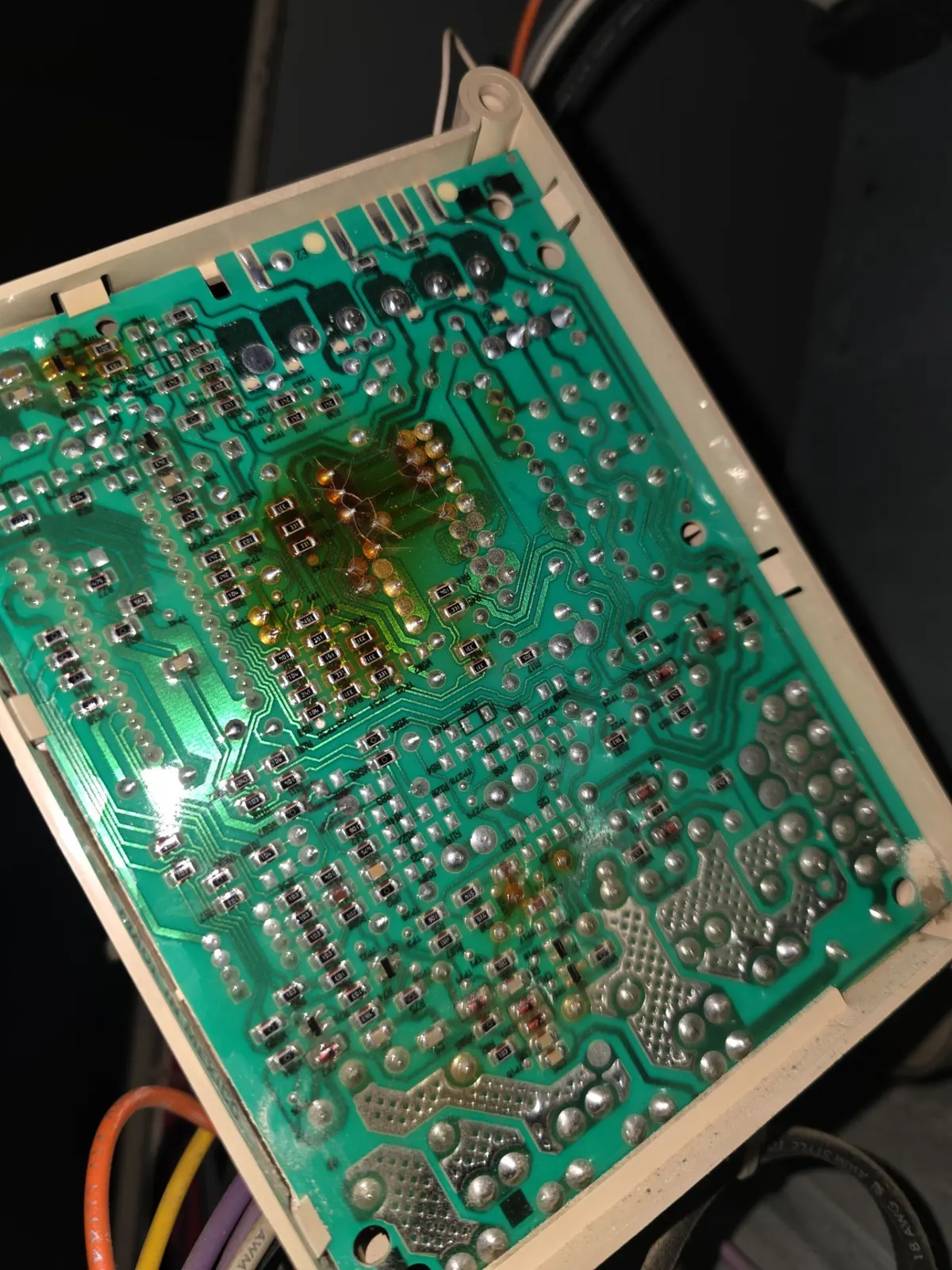 Back of a furnace control board with brown, heat-scorched solder joints