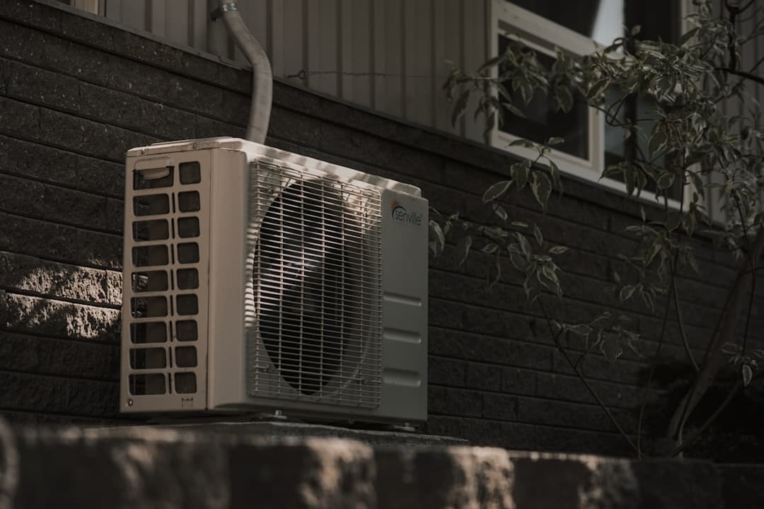 Outdoor air conditioner condenser unit beside a home