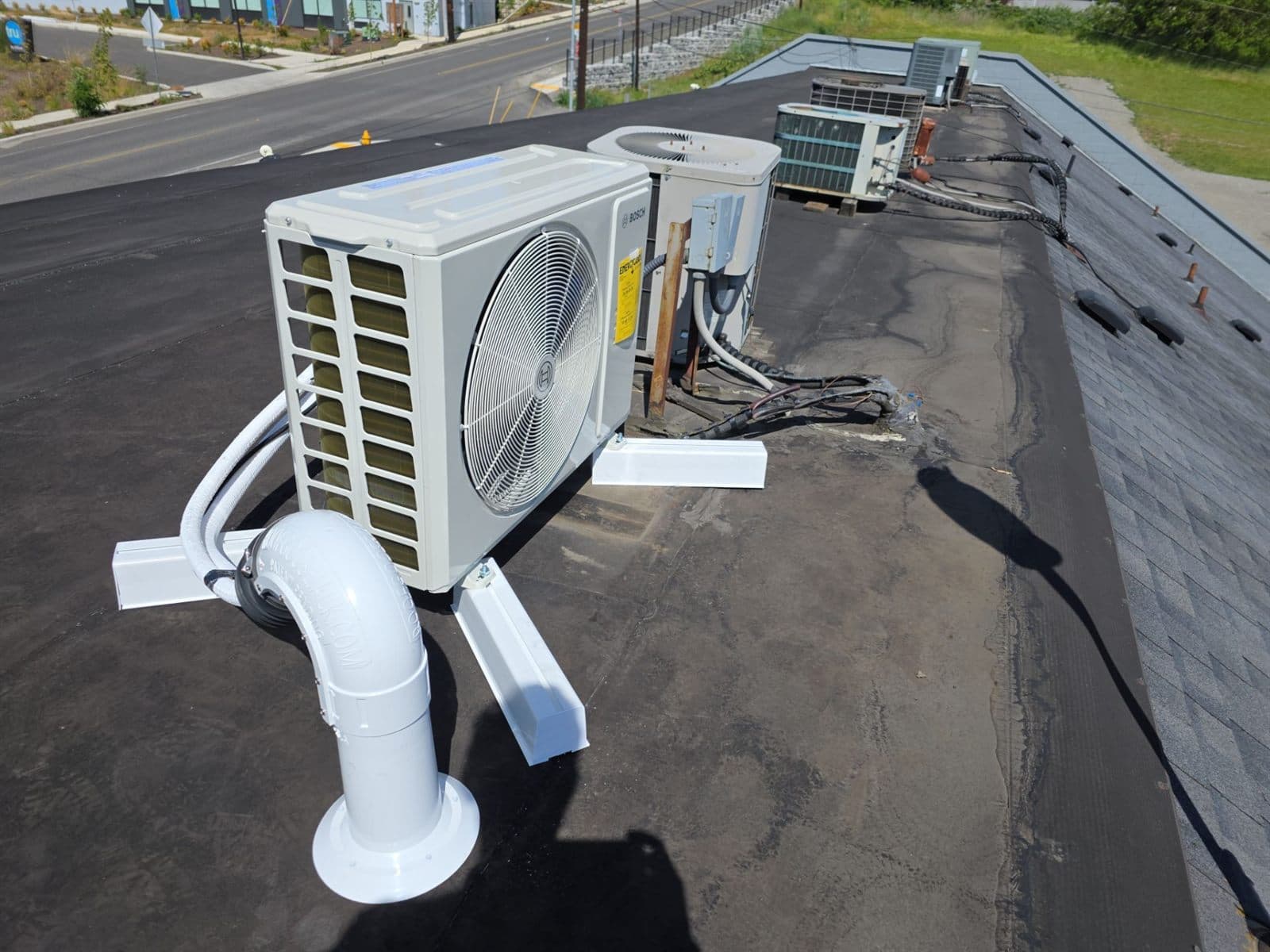 A heat pump outdoor unit newly installed on a flat commercial roof