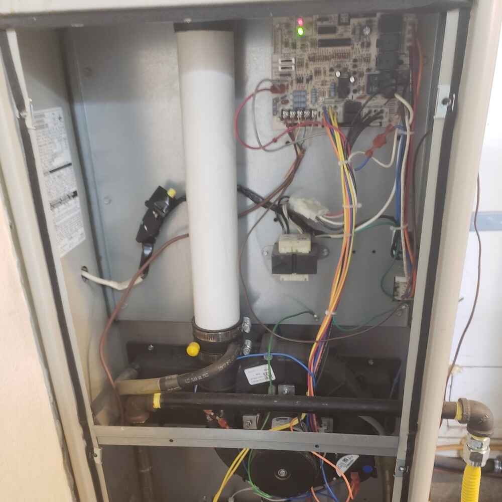 Air handler repair with the front panel removed, exposing electrical wiring, circuit board, and internal components for diagnostic service.