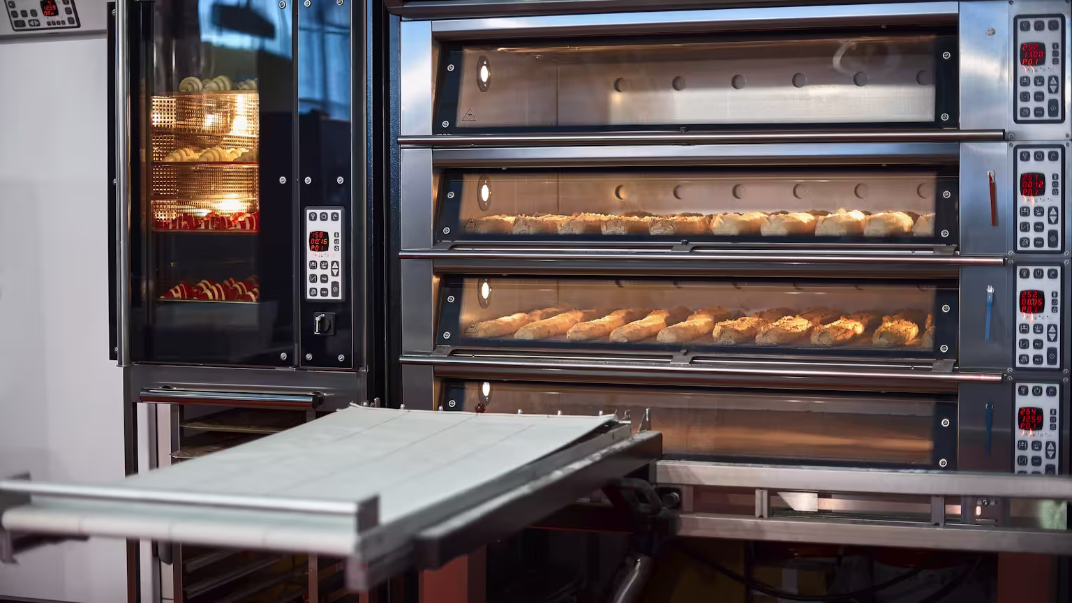 Commercial ovens repair service featuring multiple industrial bakery ovens with digital controls, actively baking bread and pastries.
