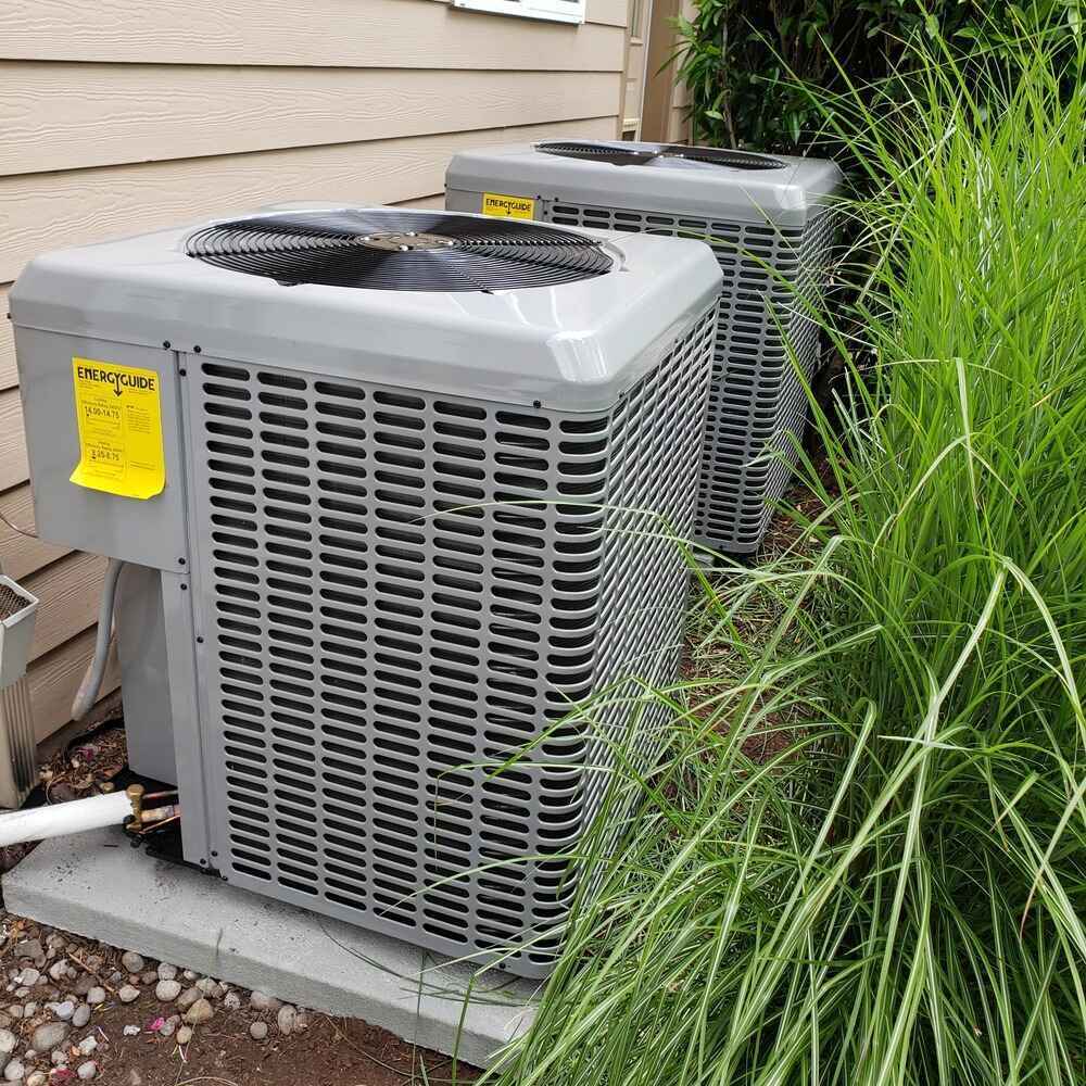 Two residential HVAC units installed next to a home, maintained by a professional HVAC Contractor Lake Oswego OR to ensure reliable and efficient climate control.